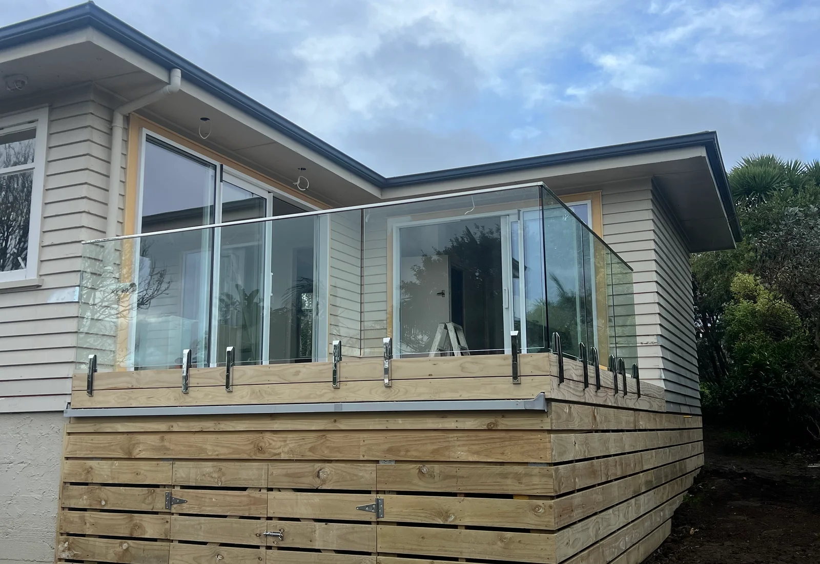 A timber deck with glass balustrade off a Raglan home