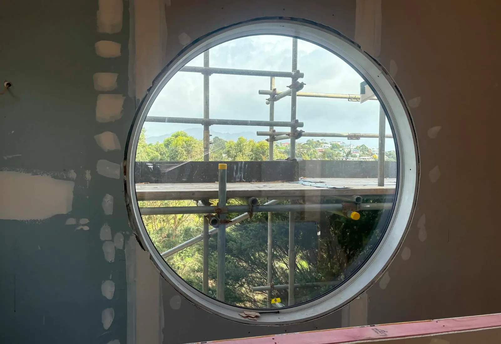 Circular window installed in the new upstairs interior, framing the view across to the harbour and hills