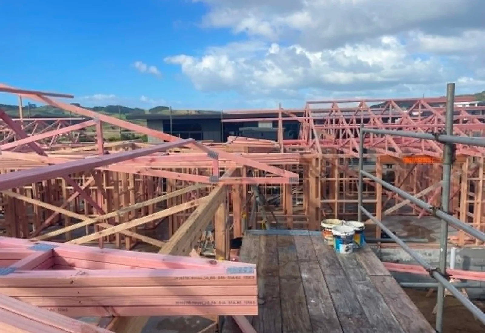 Roof trusses going up — view across the framed structure
