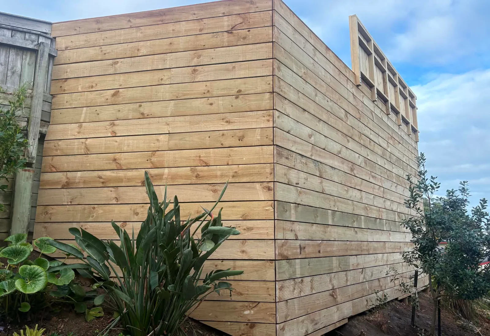 The horizontal timber privacy screen behind a Raglan deck, tying the structure into the property