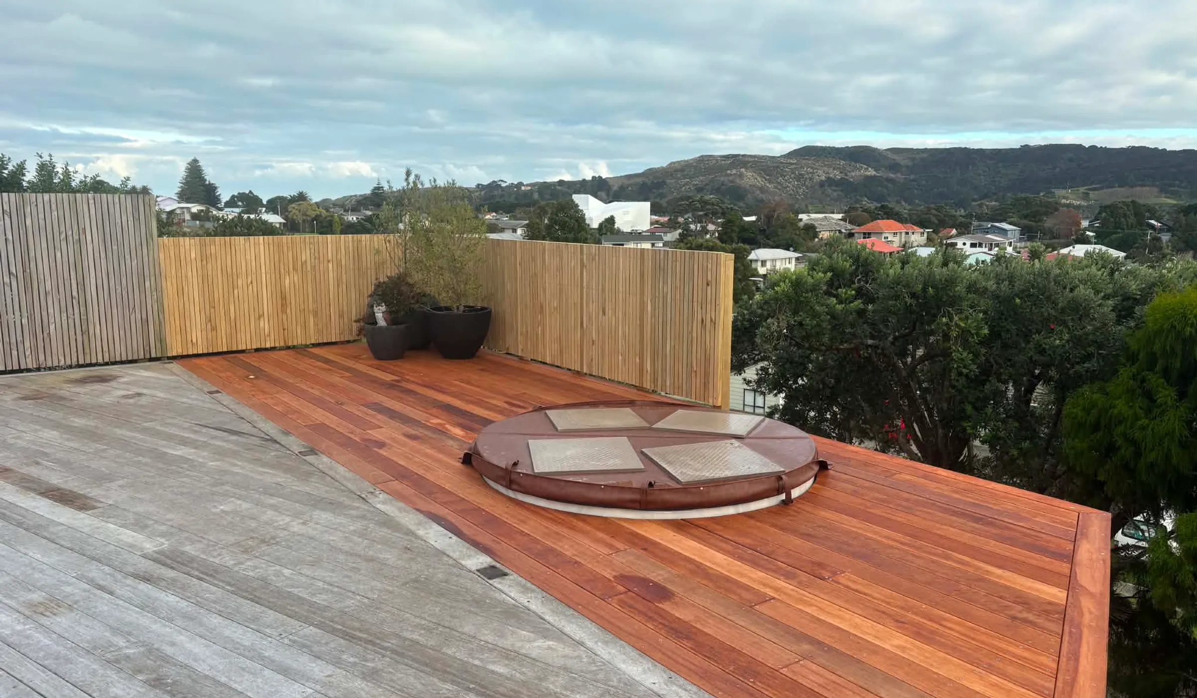 The finished hardwood deck at Andrew Park Drive, with the circular cut-out for the spa pool and a view across Raglan in the background