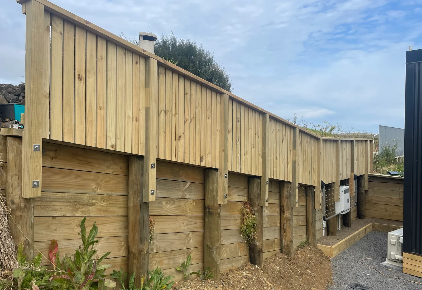 An engineered timber retaining wall on a Raglan section, with a stepped top profile following the slope